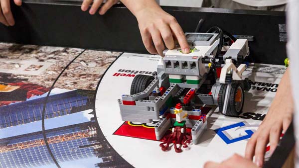 Robot LEGO® Mindstorms sur un tapis de compétition à la FIRST LEGO League en train d'être mis en route