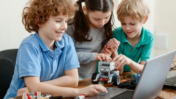 Apprendre l'informatique. Photo d'adolescents devant un ordinateur en train de programmer leur robot LEGO® Mindstorms