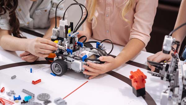 Enfants qui manipulent des LEGO® Mindstorms sur un tapis spécial à un cours de programmation robotique